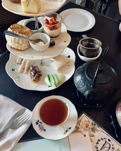 Overhead tea photo with tea pot and delicacies on a tray tea time